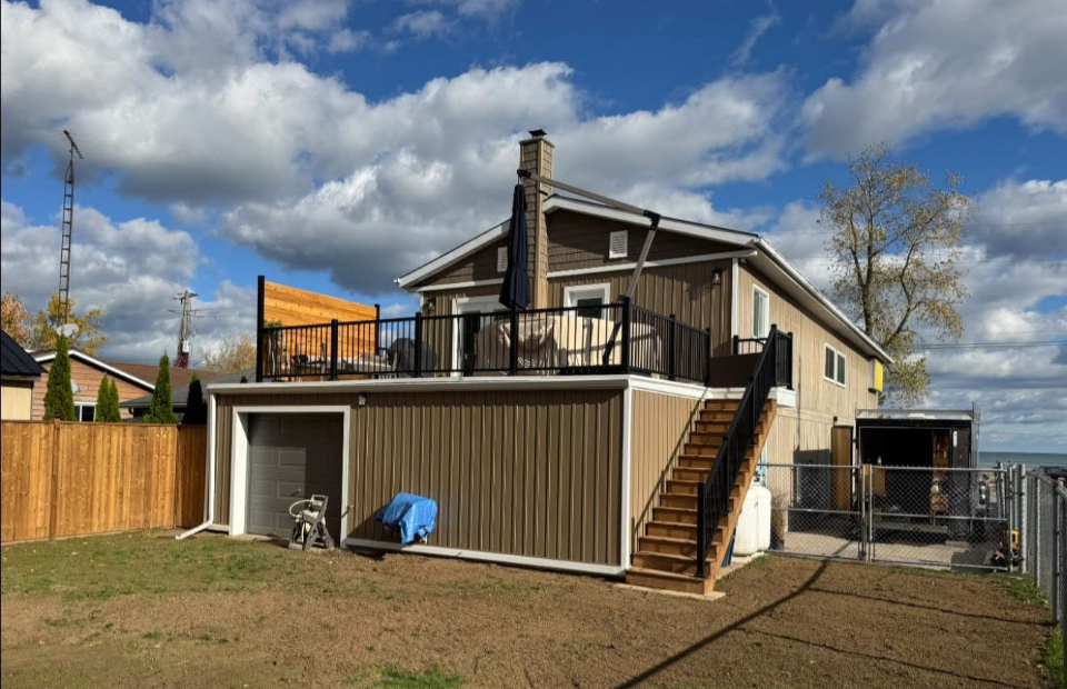 After: finished raised deck with black aluminum railings above a new garage by Kuiper Construction
